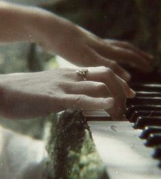 two hands are playing the piano together