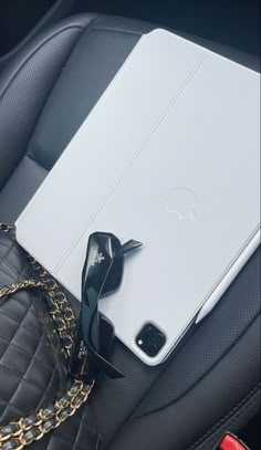 an apple ipad is sitting in the back seat of a car with sunglasses on it