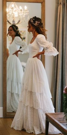 a woman is standing in front of a mirror wearing a dress with ruffles