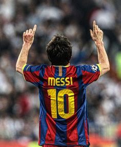 a soccer player with his hands up in the air while wearing a shirt that says messi