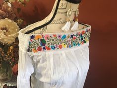 This beautiful hand embroidered Mexican blouse is comfortable, fresh and stylish With beautiful flower embroidered detailed work on the top Get the Boho style you like Perfect to wear with your favorite jeans You will love your unique one of a kind piece Is a MUST HAVE in you wardrobe Every blouse is individually handcrafted Color may vary on stitching as each blouse is unique Perfect for any occasion Perfect gift idea *accesories sold separately* **HAND WASH ONLY** Follow us on Instagram @ mard Casual Embroidered Top With Intricate Embroidery For Spring, Multicolor Embroidered Top With Embroidered Hem For Spring, Spring White Blouse With Tonal Embroidery, Spring Folk Embroidered Top With Floral Embroidery, White Blouse With Tonal Embroidery For Spring, Traditional Spring Tops With Embroidered Hem, Traditional Tonal Embroidered Top For Spring, Folk Style Blouse With Tonal Embroidery For Spring, Traditional Spring Embroidered Top With Embroidered Hem