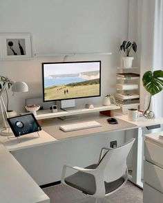 a desk with a computer monitor, keyboard and mouse on top of it in front of a window