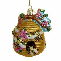 a glass ornament with a beehive hanging from it's side