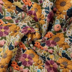 an image of a flowery fabric with many colors and flowers on it's surface