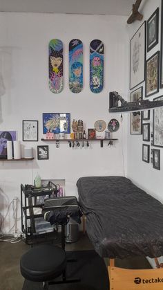 a room with several skateboards on the wall and pictures hanging above it, along with a bed