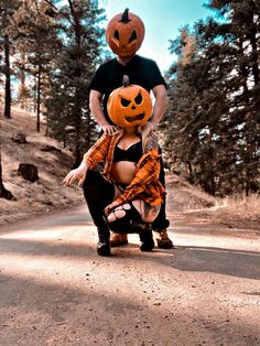 a man and woman dressed up as jack - o'- lanterns on the road