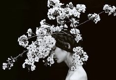 a black and white photo of a woman with flowers in her hair