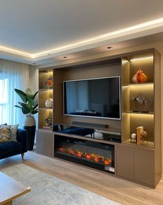 a living room with an entertainment center and couches in front of a flat screen tv