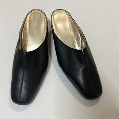 Never Worn. Black Leather. Elegant Black Slip-on Mules, Formal Synthetic Mules With Square Toe, Elegant Faux Leather Slip-on Mules, Elegant Slip-on Faux Leather Mules, Formal Flat Heel Mules Medium Width, Sleek Mules With Round Toe For Formal Occasions, Formal Closed Toe Synthetic Mules, Formal Synthetic Closed Toe Mules, Classic Black Mules For Office