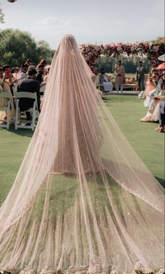 a veil draped over the back of a bride's dress at a wedding ceremony