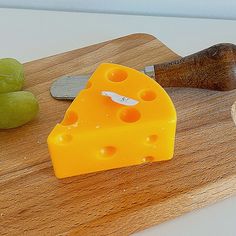 a piece of cheese sitting on top of a wooden cutting board