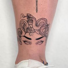 a woman's leg with a tattoo on it and an image of a snake