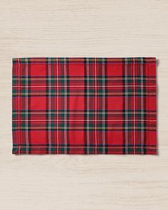 a red and green plaid placemat on top of a wooden table