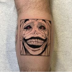 a close up of a person's arm with a tattoo on it and an image of a clown