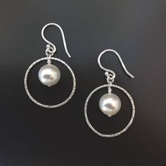 "These gorgeous earrings are made with white pearls setting inside delicate gold/ silver hoops. The texture adds a bit of extra sparkle. Perfect for dress up, wedding, everyday, and gifts for mom, wife, or bridesmaids. KEY FEATURES ▶ 1.5\" from the top curve of the earwire to the base of the earring. ▶ All components are in 925 sterling silver. Hypoallergenic. Suitable for sensitive skin. ▶ Packaged in a gift box. Makes great gifts for birthday, anniversary, or holiday. ∙ ∙ ∙ ∙ ∙ ∙ ∙ ∙ ∙ ∙ ∙ ∙ ∙ Elegant Pearl Hoop Earrings With Ear Wire, Elegant Silver Hoop Bridal Earrings, Metal Pearl Earrings For Anniversary, Silver Hypoallergenic Hoop Earrings For Wedding, Minimalist Silver Pearl Drop Bridal Earrings, Minimalist Silver Bridal Earrings With Pearl Drop, Hypoallergenic Silver Hoop Earrings For Wedding, Metal Drop Pearl Earrings For Anniversary, Small Hoop Metal Pearl Drop Earrings