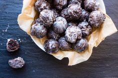 a bowl filled with chocolate covered donuts on top of a table