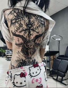 the back of a woman's body with hello kitty tattoos on her left side