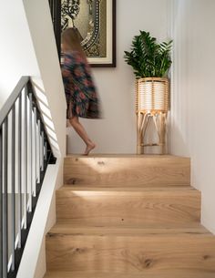 a woman walking up some stairs in a house