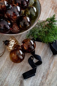 a bowl filled with lots of different types of ornaments on top of a wooden table