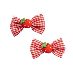 two red and white checkered bow clips with green leaves on each side, set against a white background