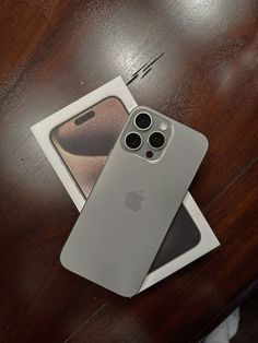 an iphone 11 pro sitting on top of a wooden table next to a card case