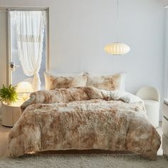 a bedroom with a bed covered in brown and white furry comforter next to a window