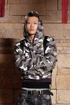 The Camo Zip-up Embroidery Hoodie is a striking blend of street style and military influences, making it a standout piece in any wardrobe. This hoodie features an all-over black-and-white camouflage print, contrasted by acid symbol motifs embroidered on the left side of the body and sleeve, adding an edgy, rebellious touch. The hoodie is designed with a central zipper for easy wear, and it includes practical pockets near the hem. The ribbed cuffs and hem provide a snug fit, while the cropped sil Sneakers And Socks, Embroidery Hoodie, Half Shirts, Sweat Hoodie, Jean Accessories, Camouflage Print, Knit Pants, Zipper Hoodie, Denim Pant