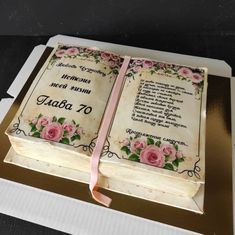 an open book cake with pink roses on it