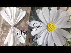 two white paper flowers with yellow centers on them and the words pavan sai crafts