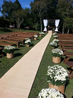 an image of a wedding ceremony with flowers on the aisle and benches in the grass