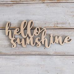 the word hello sunshine spelled in wooden letters on a white wood planks background with copy space