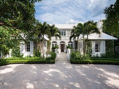 a large white house surrounded by trees and bushes