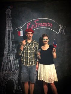 a man and woman standing next to each other in front of the eiffel tower