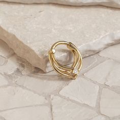 Handcrafted with precision and designed to perfection, this triple layered septum ring combines modern elegance with a stylish edge. It features a single prong-set diamond at the center for a touch of sparkle.Materials:• 14K Solid Gold - Available in yellow, rose or white gold.• Genuine or lab grown white diamonds (Weight: 0.03ct VS-SI/G-H)Measurements:• Inner diameter: 5/16" (8mm)• Number of diamonds: 1• Diamond size: 2mm Fits: septum, helix, daith, tragus and earlobe piercings. Item sold singl Elegant 14k Gold Septum Ring For Anniversary, Elegant 14k Gold Huggie Septum Ring, Elegant Internally Threaded Septum Ring For Anniversary, Elegant Gold Stackable Septum Ring, Minimalist Yellow Gold Septum Ring For Wedding, Earlobe Piercings, Septum Hoop, Daith Jewelry, Tragus Hoop