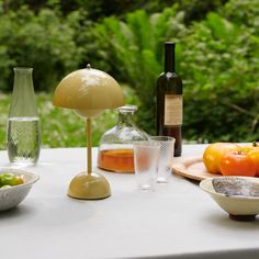 a table topped with plates and bowls filled with food next to bottles of wine on top of a window sill