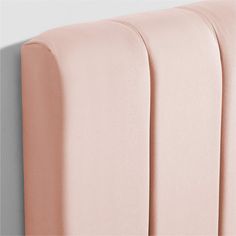 an upholstered headboard with pink sheets