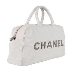 Authentic Chanel bowler bag with a white canvas and gray leather lettering. Features white and gray canvas, leather handles, leather lined interior with zipper pockets, rear zipper pocket, and silver hardware with gray CC zipper pull. Hologram reads: 6648338 Made in 2000-2002 Made in Italy Strap drop: 5" White Designer Satchel With Large Capacity, Designer Canvas Bag With Detachable Handle For Travel, Designer Travel Canvas Bag With Dust Bag, Luxury White Canvas Bag With Top Carry Handle, Designer Canvas Satchel Bag For Travel, Designer White Coated Canvas Shoulder Bag, White Weekender Shoulder Bag With Leather Handles, Luxury White Tote Travel Bag, White Weekender Bag With Double Handle For Travel