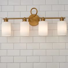 a bathroom light that is on the wall in front of a white brick wall and floor