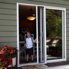 a young boy standing in the doorway of a house