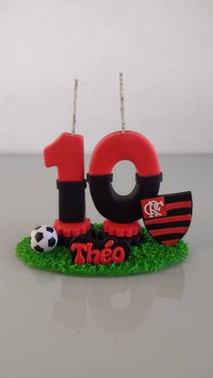 a cake shaped like the number ten with soccer balls on it's grass base