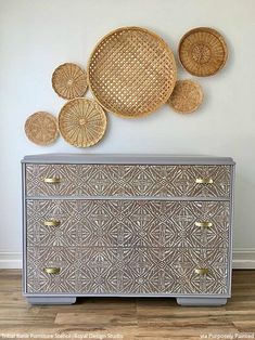 an antique dresser with wicker baskets on the top and bottom, against a white wall