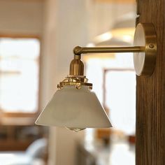 a light that is on the side of a wooden pole in a room with white walls