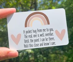 a person holding up a card with a rainbow on it and the words, a pocket hug from me to you