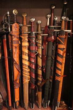 many different types of umbrellas are lined up on the wall in front of each other