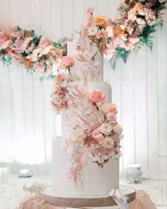 a white wedding cake with pink and orange flowers