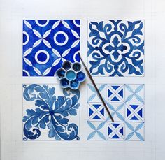 some blue and white tiles are being worked on with a paintbrush in the middle