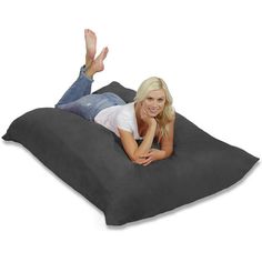 a woman laying on top of a bean bag chair