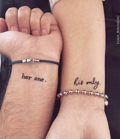 two people with matching tattoos on their arms, one is holding the other's hand