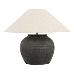 a black vase with a white shade on it's side and a light in the middle