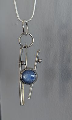 An abstract sterling silver pendant, approximately 1.5 inches long, highlights a glorious mid-blue kyanite cabochon.  Simple, abstract, not traditional, this necklace looks amazing against bare skin, but also with a sweater or even a t-shirt.  Versatile, celebratory, fun! Abstract Silver Jewelry, Silver Kyanite Jewelry As Gift, Silver Kyanite Jewelry For Gift, Kyanite Necklace, Rock Rings, Simple Abstract, Wifi Signal, Silver Cleaner, Blue Sodalite